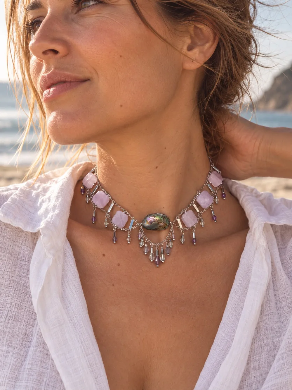 Modelka na plaży w chokerze z różowych kamieni i muszli abalone